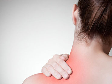 Rear view of a young woman touching her back